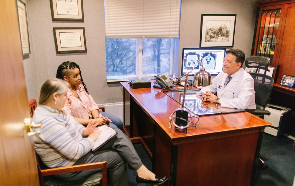 Dr. Girgis consulting with patients in his office